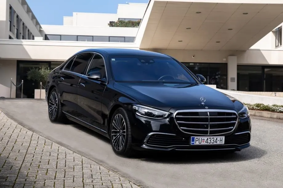 Black Mercedes S-Class parked at a hotel entrance