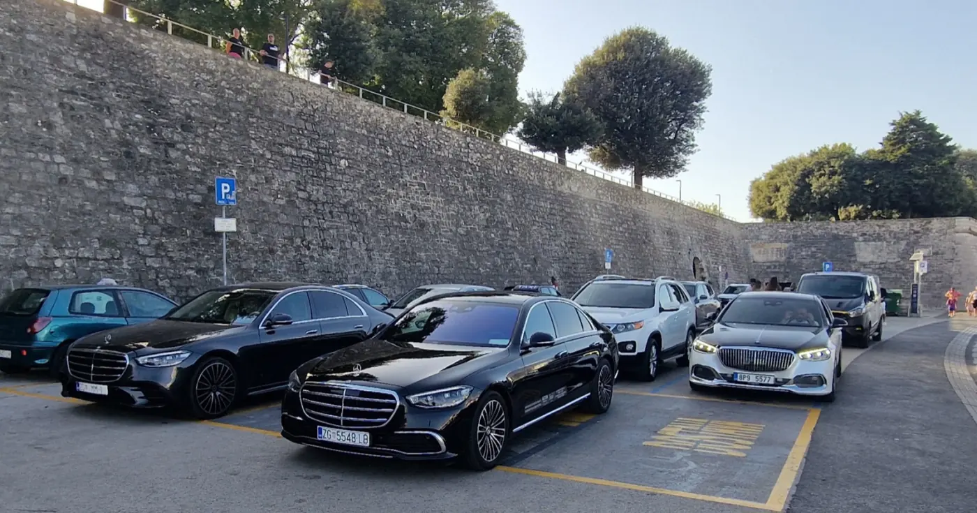 Black Mercedes S-Class by old stone walls